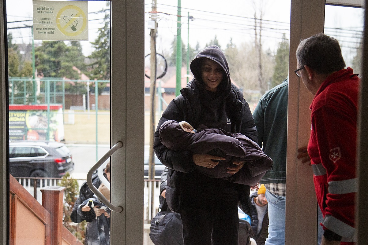 Egy fiatal ukrajnai édesanya érkezik a Piroska utcai ideiglenes befogadóhelyre. Kép: Kovács Bence