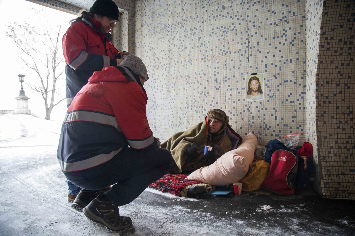 Kovács Bence | Az utcai gondozószolgálat egy hajléktalan embert lát el Budapesten