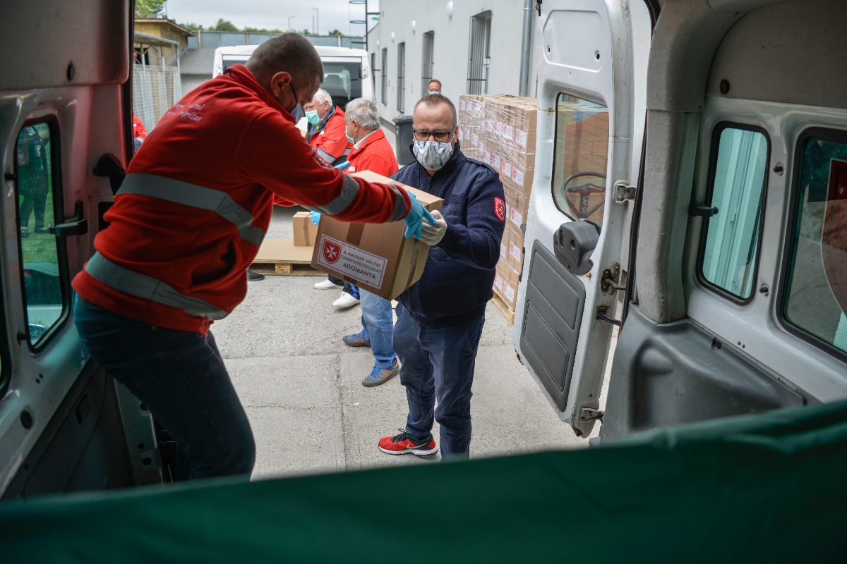 Majoros Árpád | Csatárláncban pakolják az adományokat a kiszállításhoz a Máltai Szeretetszolgálat munkatársai Győrben