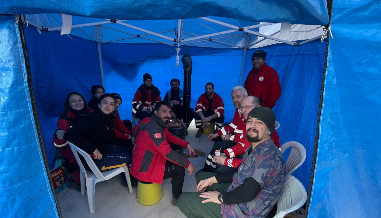 A máltai szakemberek egy sátorban melegednek a helyi segítő csapatok tagjaival